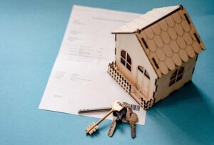 Une petite maison avec des clés et un contrat de prêt hypothécaire