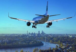 An airplane flying into a beautiful city.