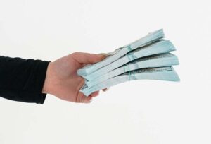 A mans hand passing stacks of money